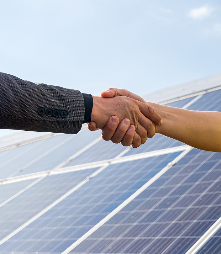 two people having shaking hands against solar panel after conclusion agreement renewable energy 1